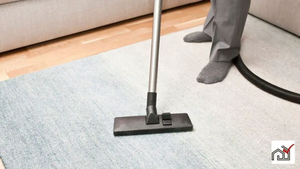 Man vacuuming his home carpet