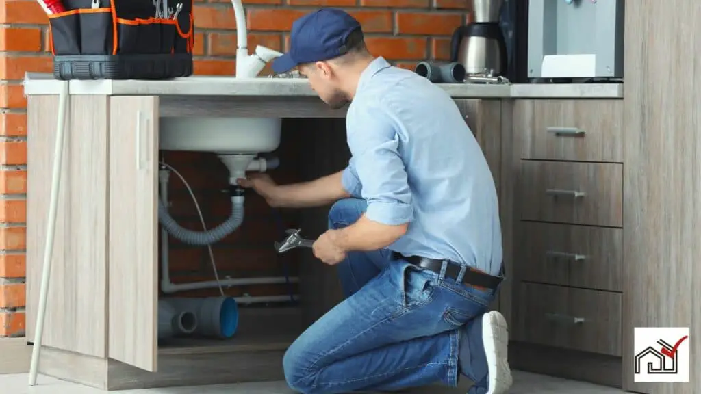 Plumber installing kitchen sink drain at an ideal height
